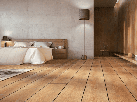 A bedroom with wooden floors and a bed.