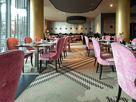 A restaurant with pink chairs and tables in it