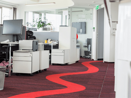 A red carpet in an office setting with white furniture.