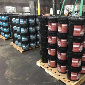 A warehouse filled with lots of buckets of paint.